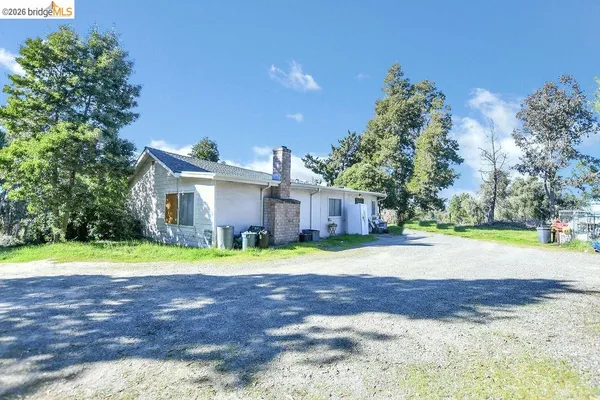 a front view of a house with a yard and trees