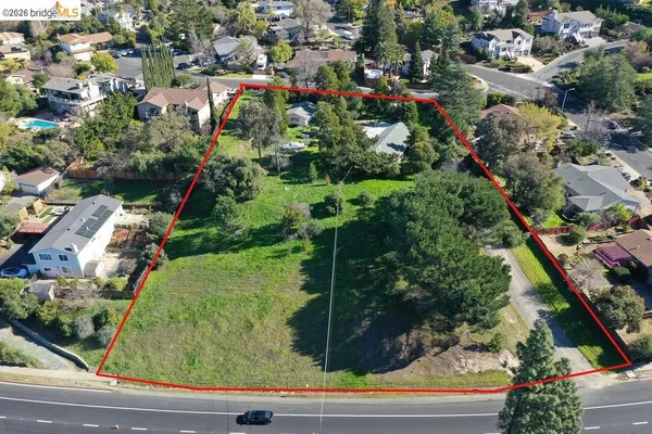 an aerial view of residential houses with outdoor space and street view