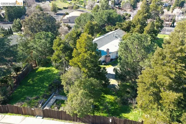 an aerial view of residential house with outdoor space and trees all around