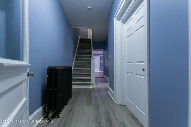 a view of a hallway with wooden floor and entryway