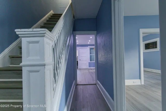 a view of a hallway with wooden floor and entryway