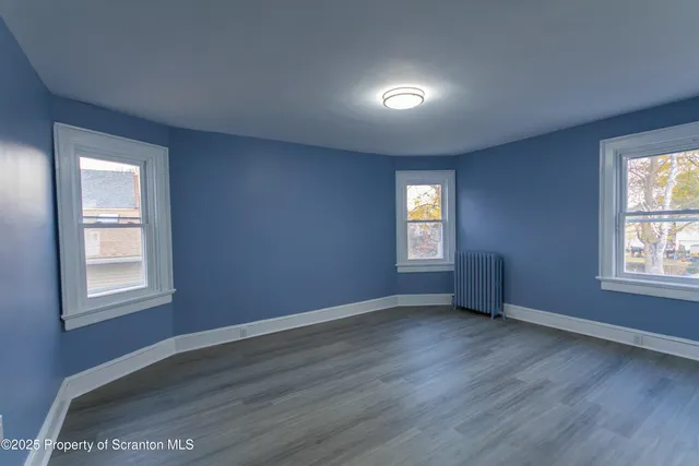 a view of an empty room and wooden floor