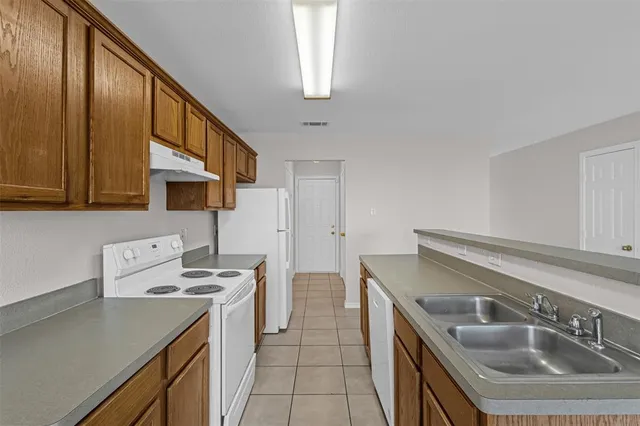a kitchen with a sink a stove a refrigerator and cabinets