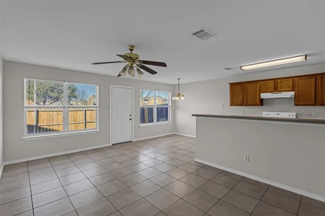 a view of an empty room with window and cabinet