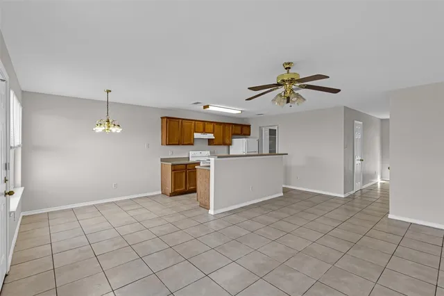 a view of a livingroom with a chandelier fan and windows