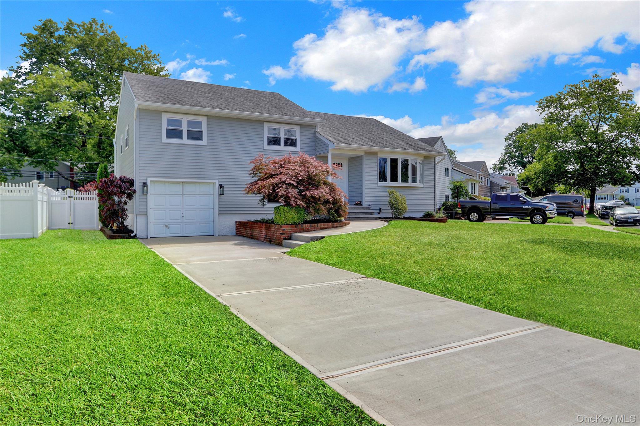 3621 Regent Lane Wantagh, NY 11793 - Photo 2 of 24 a front view of a house with a yard and garage