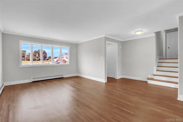 an empty room with wooden floor and window