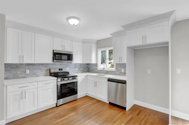 a kitchen with white cabinets stainless steel appliances and sink