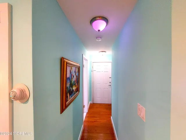a kitchen with a refrigerator and wooden floor
