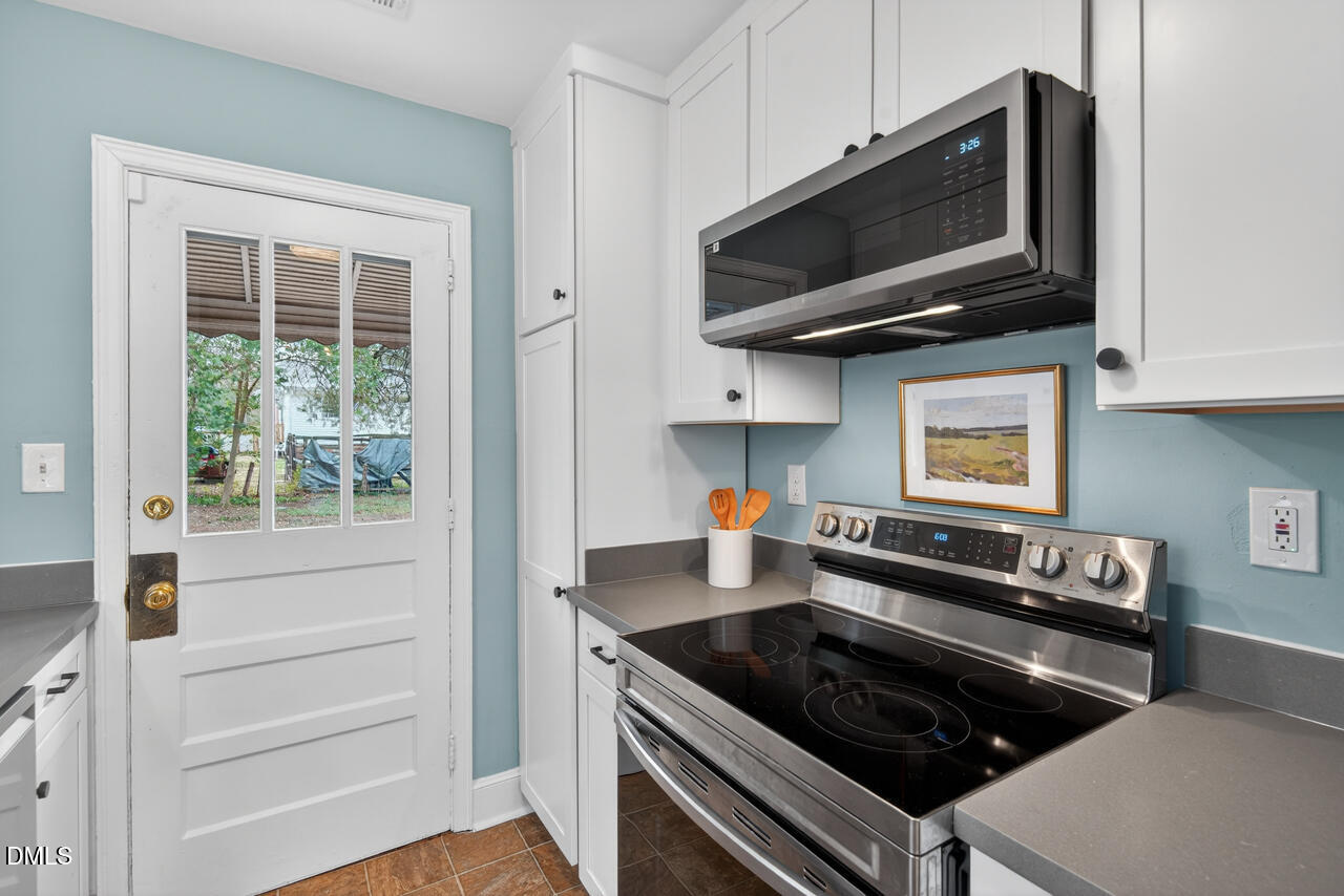1811 Forest Road Durham, NC 27705 - Photo 11 of 26 a kitchen with stainless steel appliances granite countertop a stove and a microwave