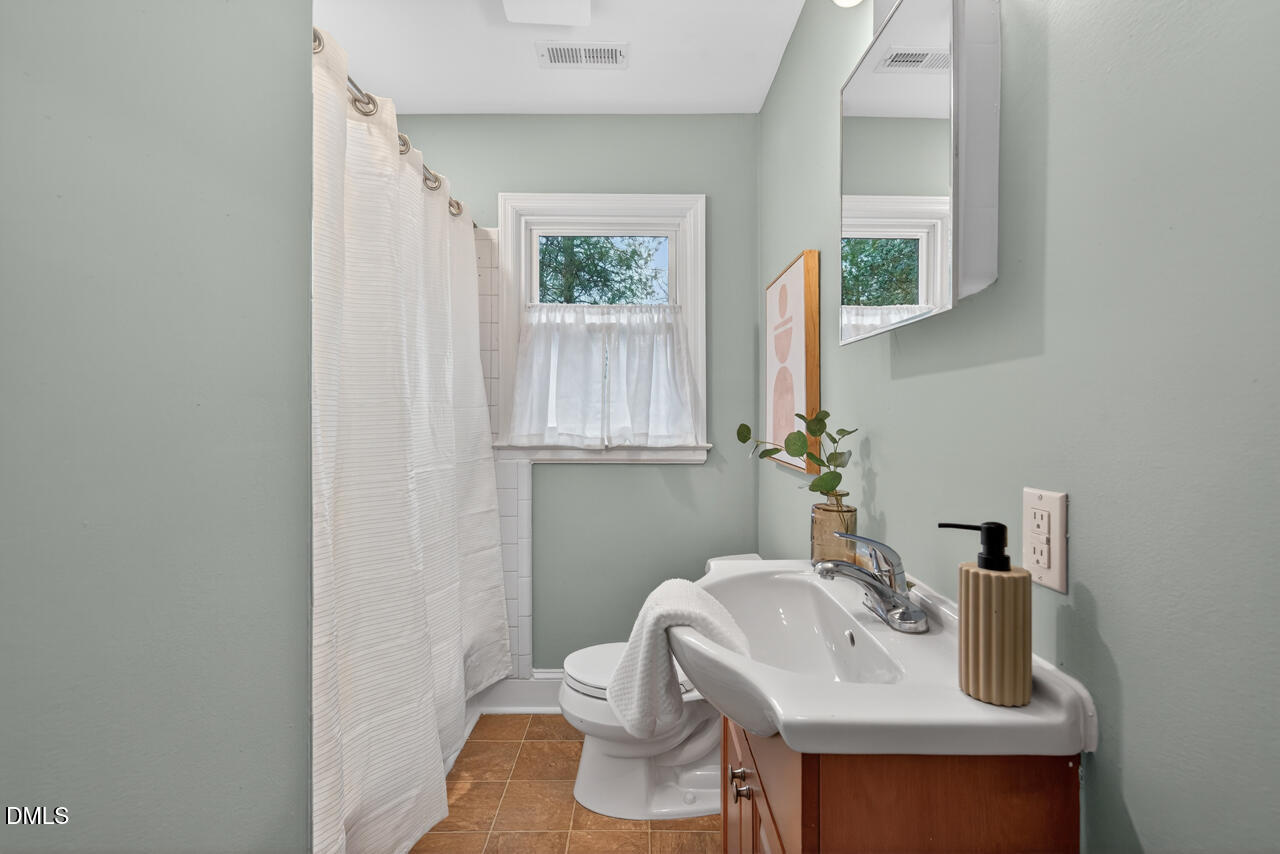 1811 Forest Road Durham, NC 27705 - Photo 13 of 26 a bathroom with a sink toilet and mirror