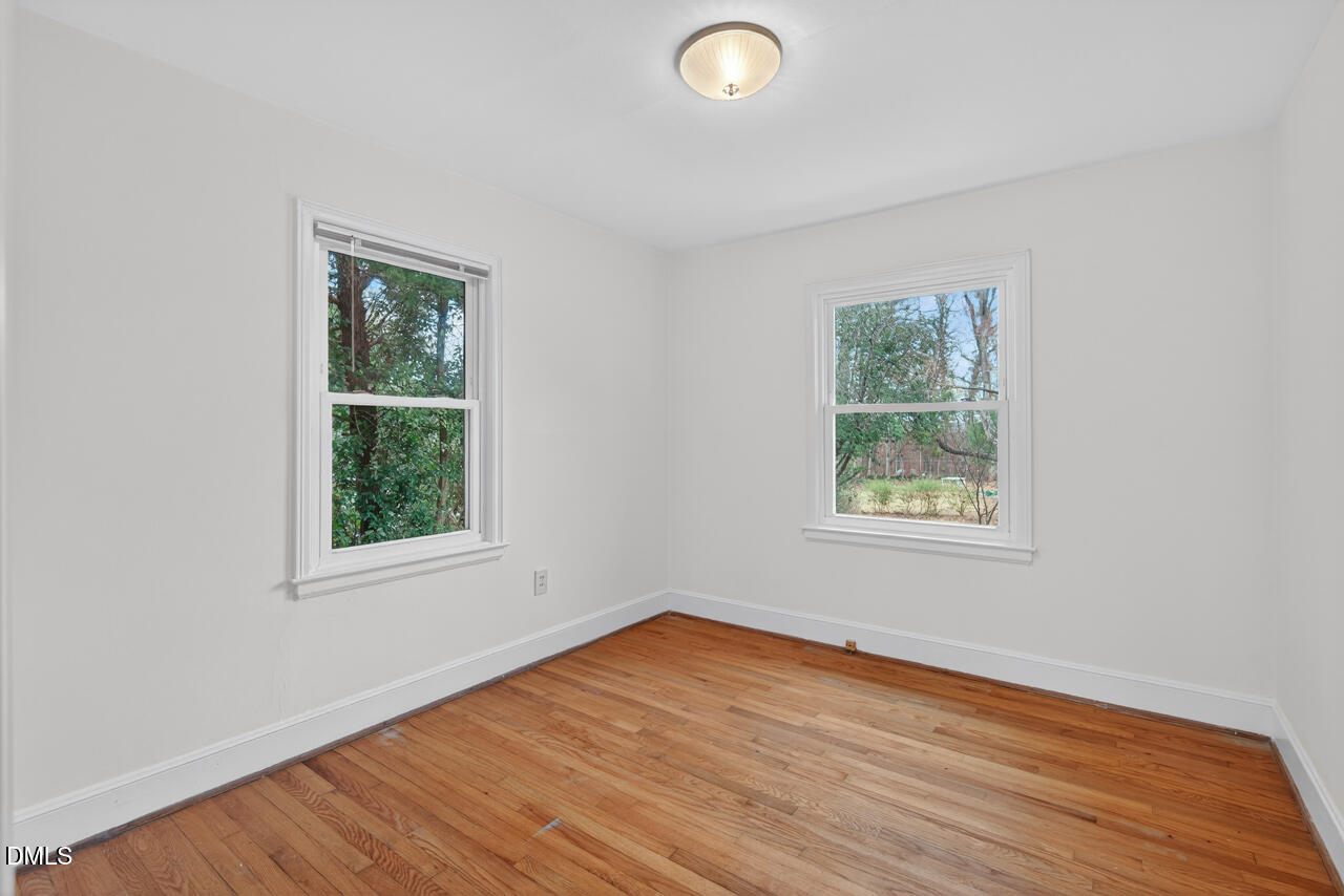 1811 Forest Road Durham, NC 27705 - Photo 16 of 26 an empty room with wooden floor and windows