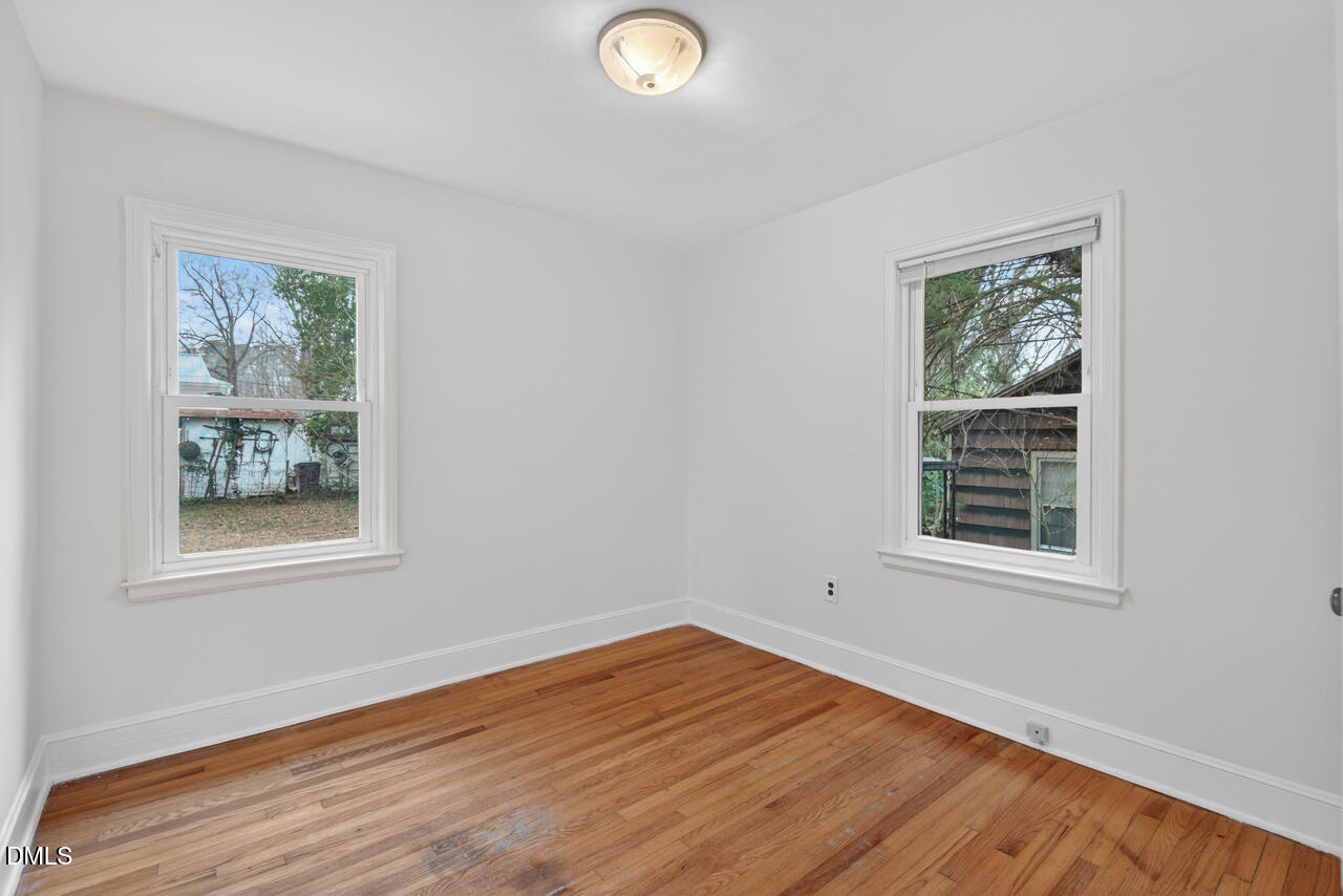 1811 Forest Road Durham, NC 27705 - Photo 17 of 26 an empty room with wooden floor and windows