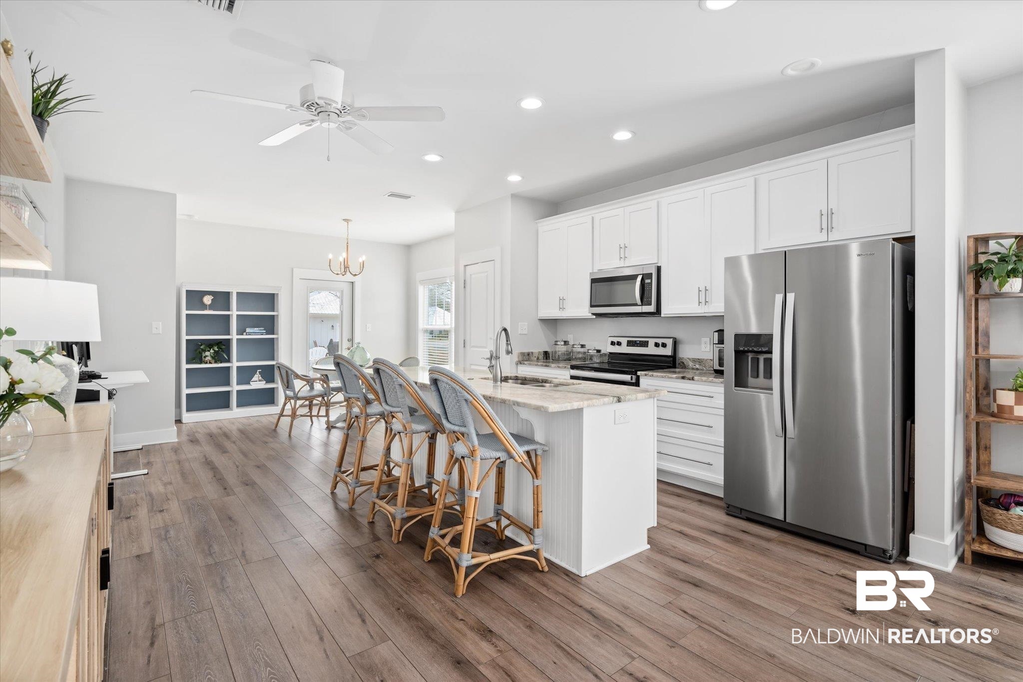 8056 Carmel Circle Foley, AL 36535 - Photo 6 of 28 Kitchen with a breakfast bar, a center island with sink, appliances with stainless steel finishes, hardwood / wood-style floors, and white cabinets
