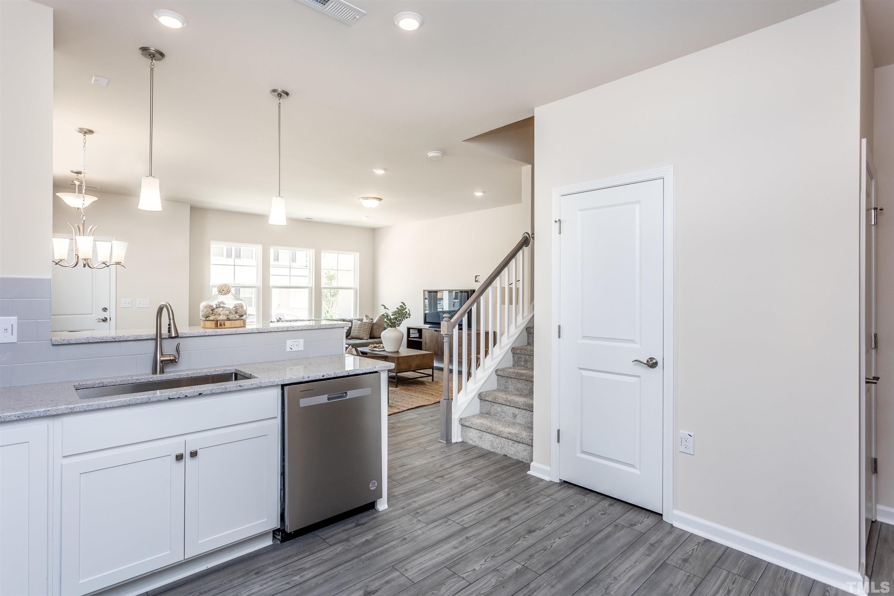 4900 Megara Run, Unit ROYAL Raleigh, NC 27603 - Photo 12 of 22 a kitchen with stainless steel appliances granite countertop a sink a counter space and wooden floor