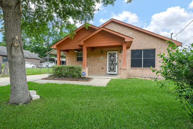 a front view of a house with a garden and yard