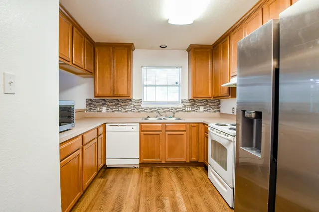 a kitchen with stainless steel appliances granite countertop a stove a sink and a refrigerator