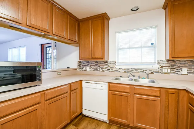a kitchen with granite countertop cabinets stainless steel appliances a sink and window