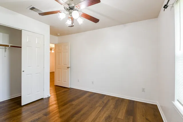 a view of an empty room with wooden floor
