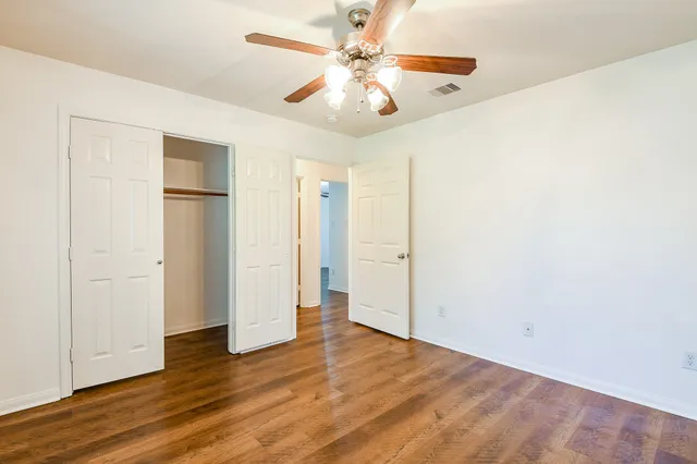 a view of an empty room with wooden floor