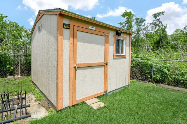 a backyard of a house with lawn chairs plants and grass