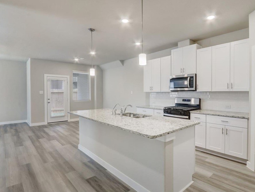8403 Arden Valley Lane Houston, TX 77063 - Photo 11 of 32 a kitchen with stainless steel appliances granite countertop a sink dishwasher a stove and a refrigerator with wooden floor