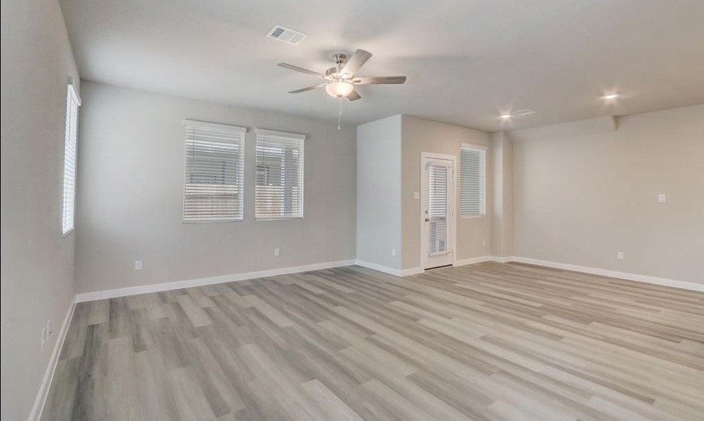 8403 Arden Valley Lane Houston, TX 77063 - Photo 3 of 32 a view of an empty room with wooden floor and a window