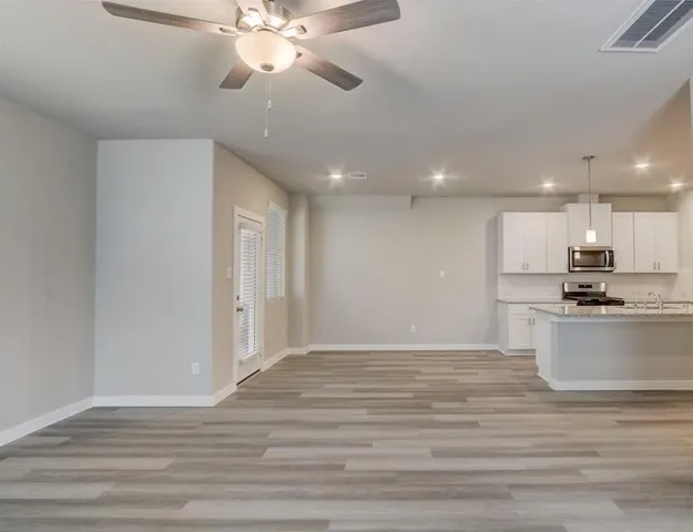 a view of kitchen with granite countertop cabinets and refrigerator