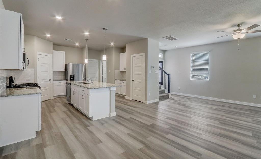 8403 Arden Valley Lane Houston, TX 77063 - Photo 7 of 32 a large kitchen with a center island wooden floor stainless steel appliances and cabinets