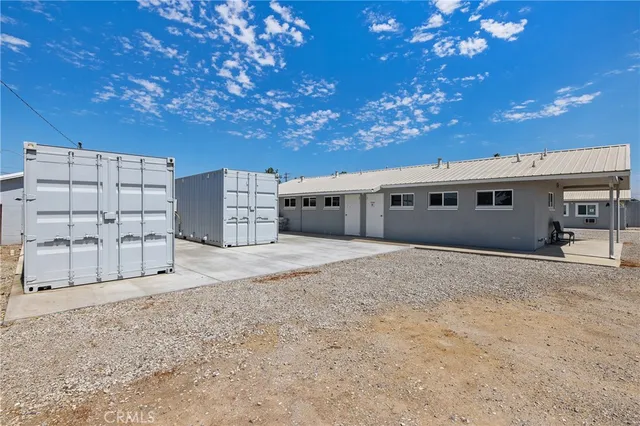 a view of a refrigerator in kitchen and an empty room