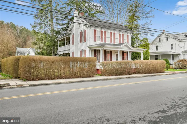 a view of a house with a yard and large tree