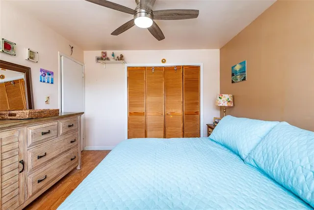 a bedroom with a bed and a flat tv screen on dresser