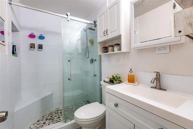 a bathroom with a sink a toilet and shower