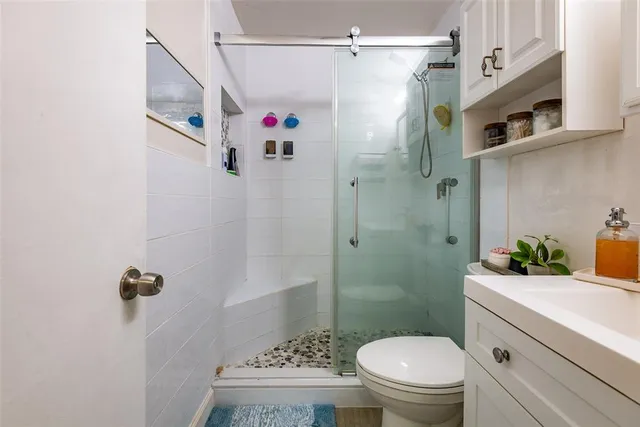 a bathroom with a shower a toilet and a sink