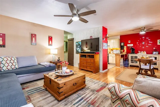 a living room with furniture a flat screen tv and a chandelier