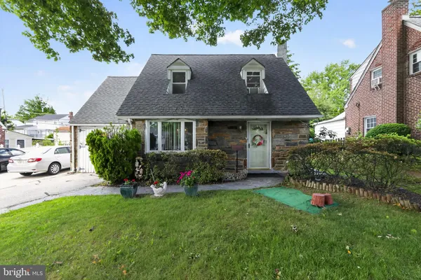 a front view of a house with a yard and trees
