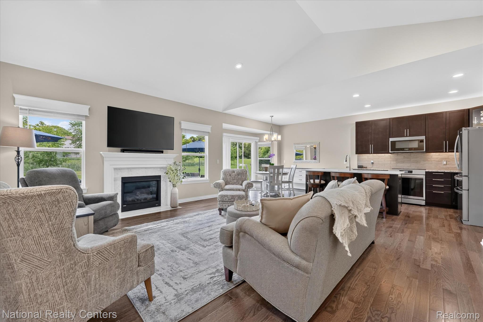 740 North Mill Street South Lyon, MI 48178 - Photo 13 of 56 Open-concept living space featuring vaulted ceilings and wood-finish flooring