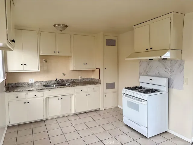 a kitchen with granite countertop white cabinets and white appliances