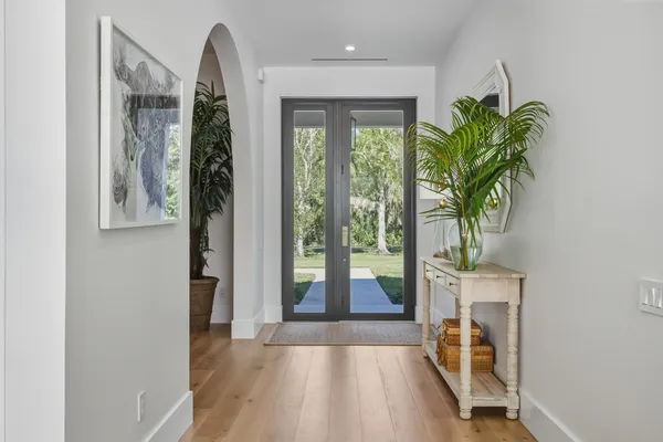 a view of a hallway with wooden floor and a potted plant