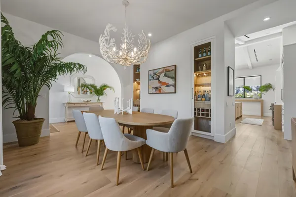 a view of a dining room with furniture a chandelier and wooden floor
