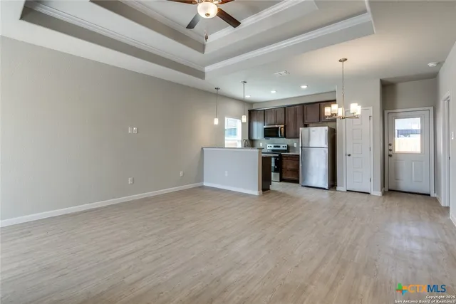 a view of a kitchen with a sink and a refrigerator
