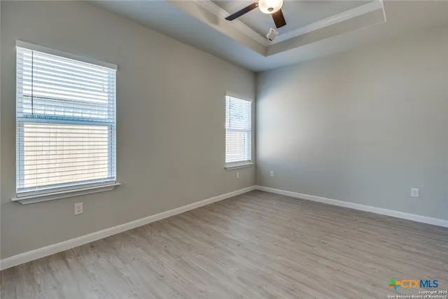 an empty room with a window and wooden floor