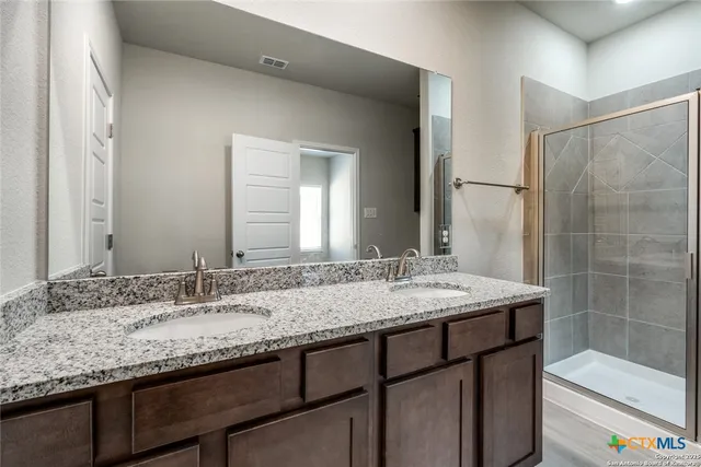 a bathroom with a granite countertop sink and a mirror