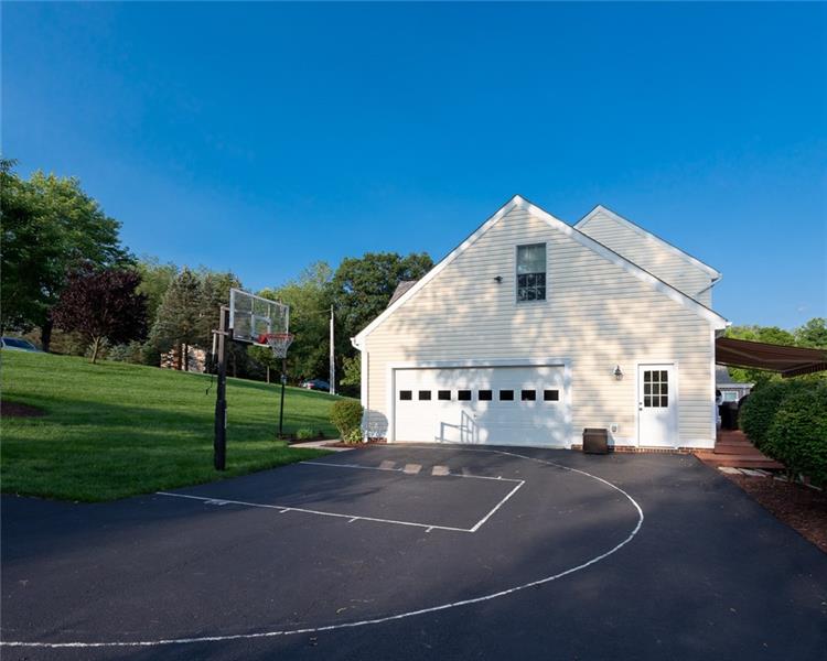 2317 Mcdevitt Road Sewickley, PA 15143 - Photo 23 of 25 Basketball hoop with lines on flat portion of driveway. 2-car garage with additional workshop space.