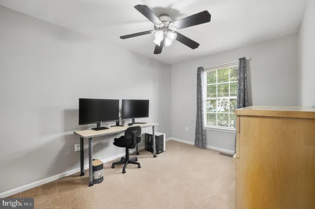 a view of a livingroom with workspace and a window