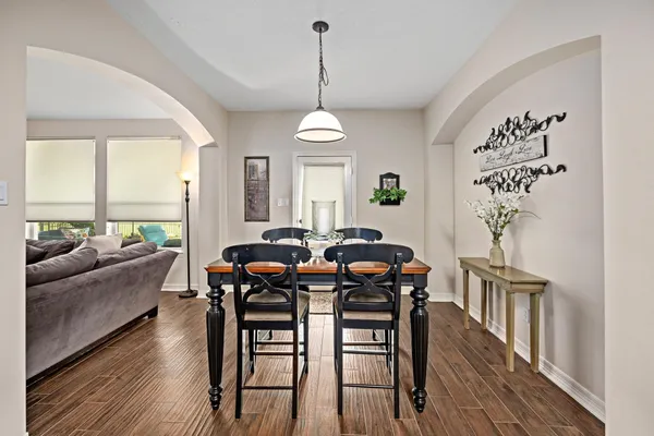 a dining room filled chandelier and wooden floor
