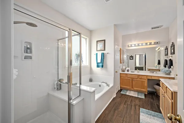 a bathroom with a tub a sink and mirror