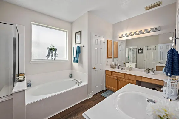 a bathroom with a tub a sink and a shower