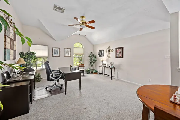 a view of a workspace with furniture and a window