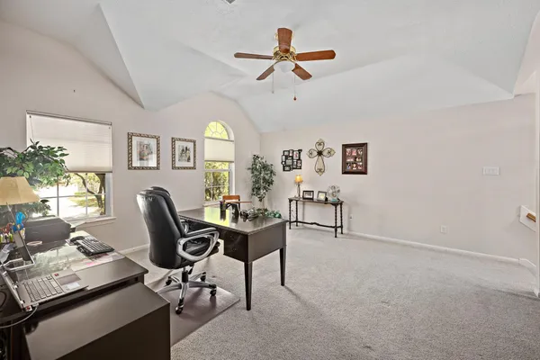 a living room with furniture a ceiling fan and a window